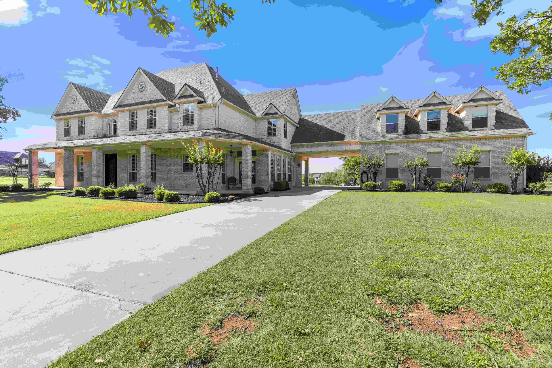 Wide front elevation showing the full brick estate with porte-cochere and dormer windows
