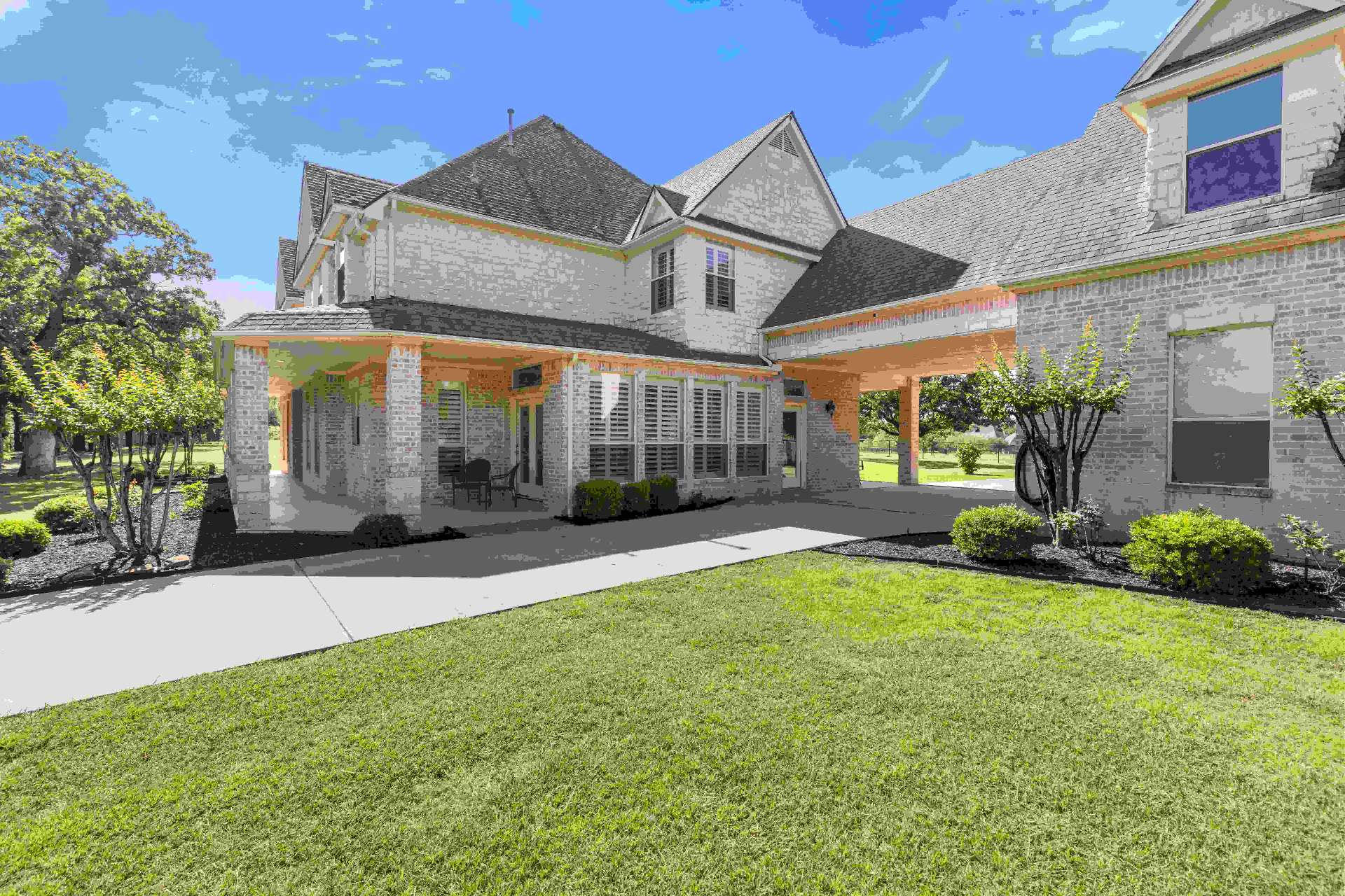 Front of home with porte-cochere and covered front porch