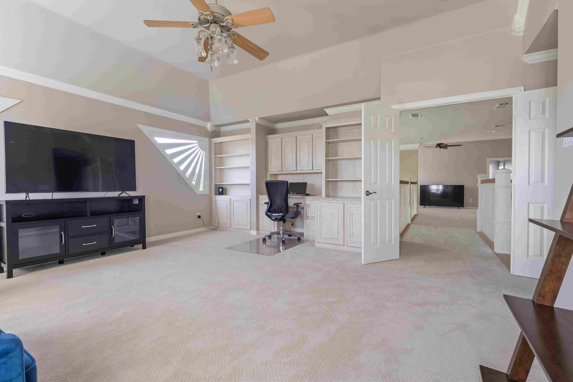 Upstairs loft with built-in office cabinetry and vaulted ceiling