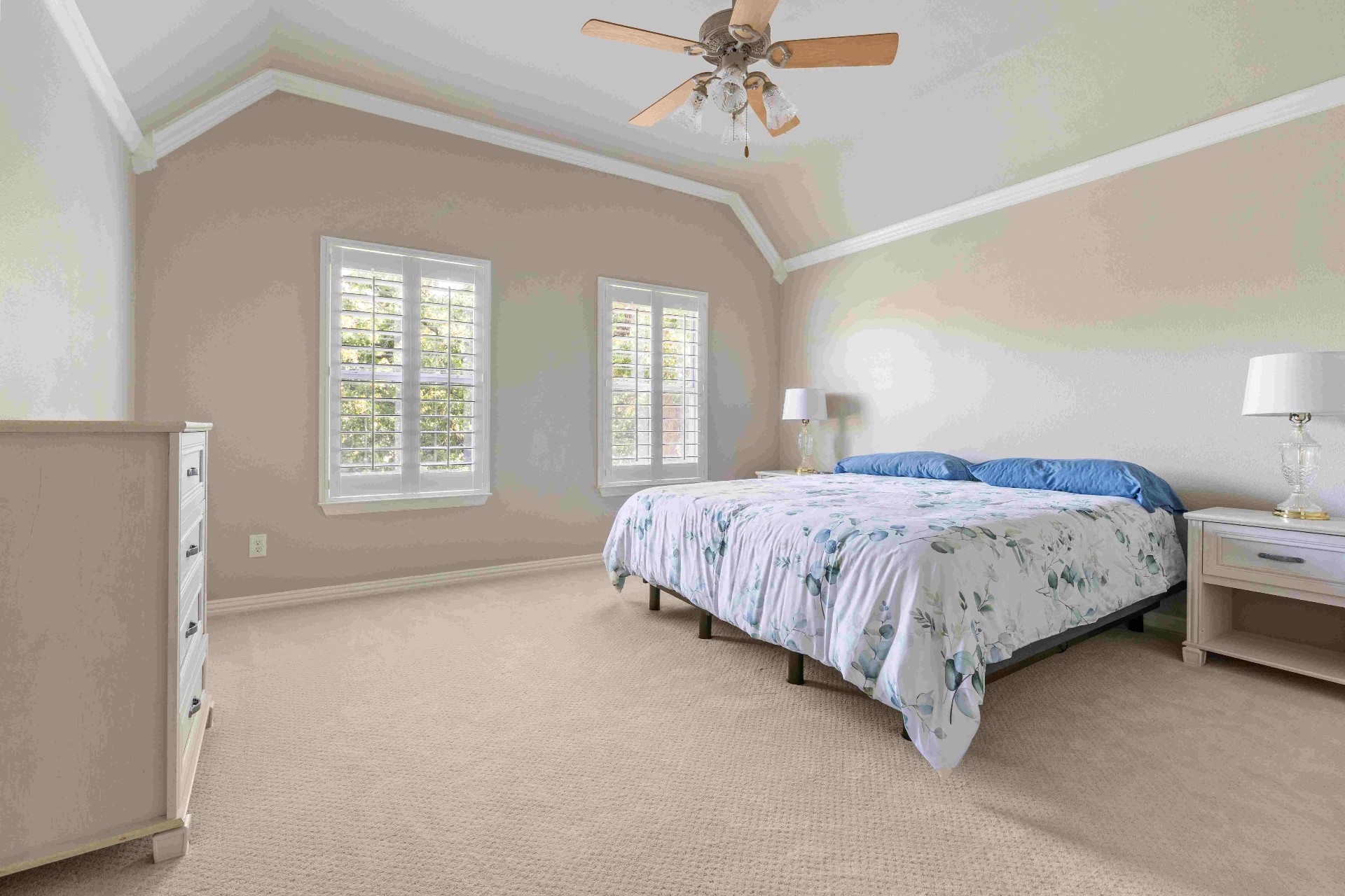 Secondary bedroom with vaulted ceiling, plantation shutters, and king bed