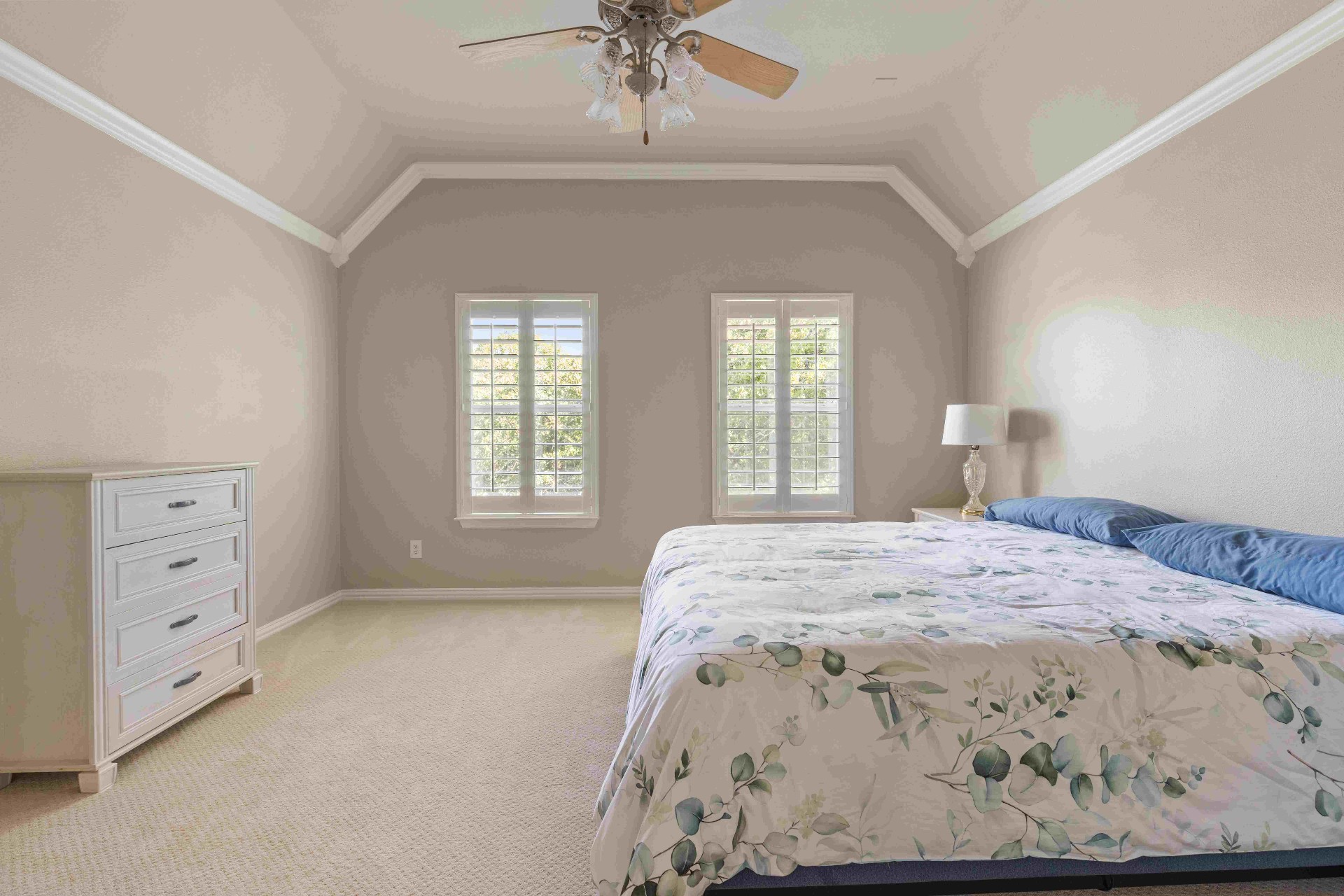 Primary bedroom with vaulted ceiling and plantation shutters
