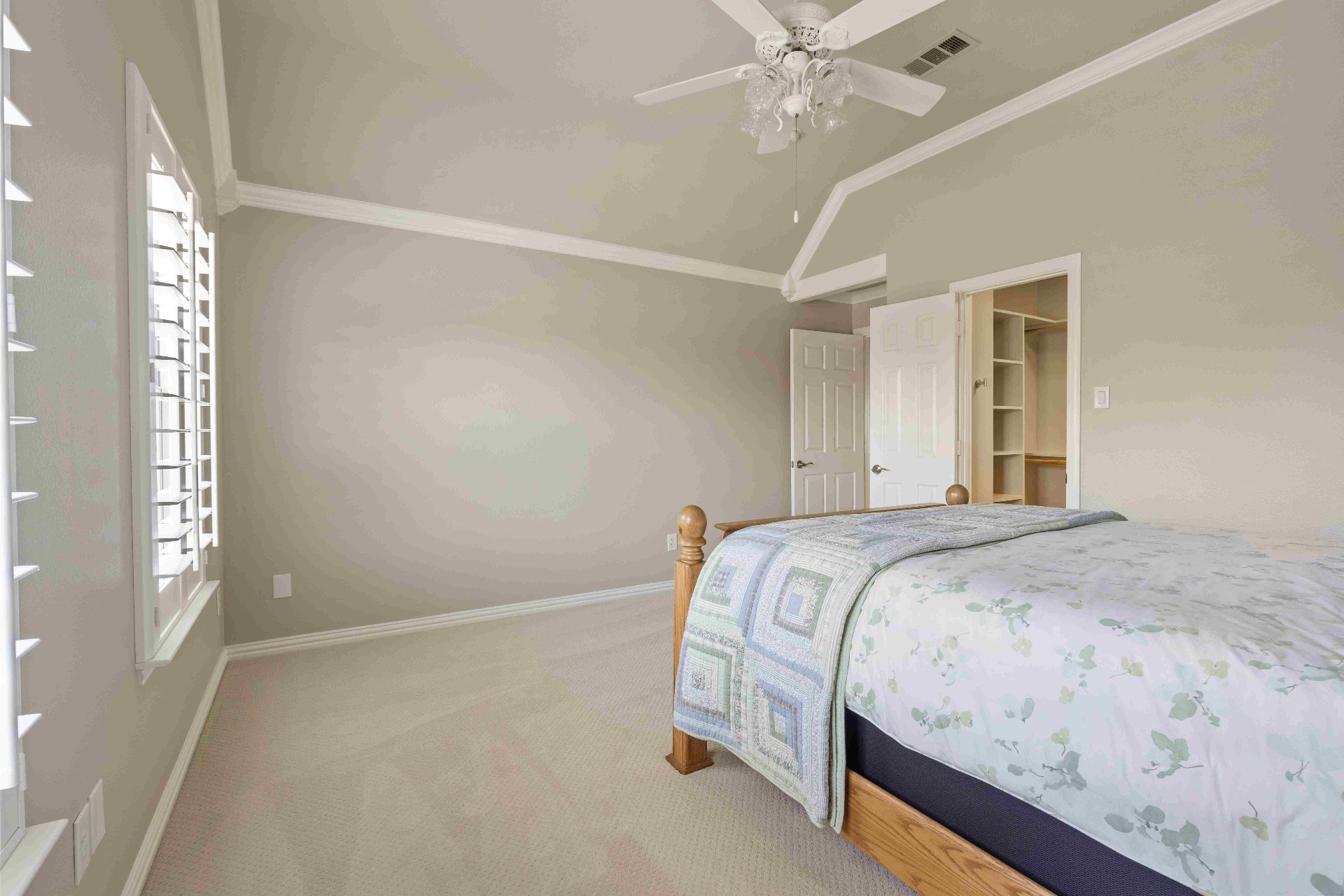 Secondary bedroom with vaulted ceiling, plantation shutters, and walk-in closet