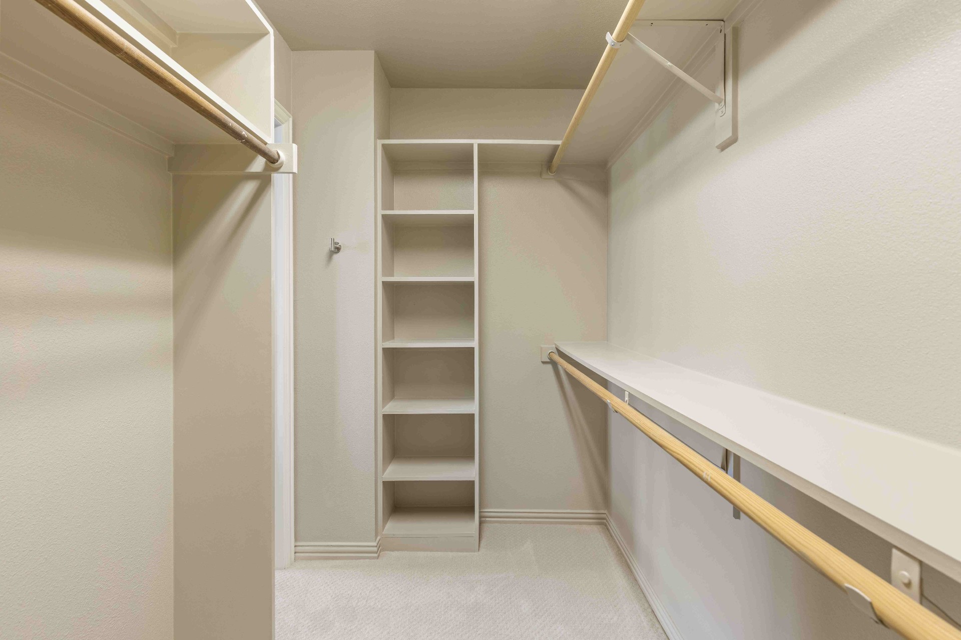 Secondary bedroom walk-in closet with built-in shelving and double hanging rods