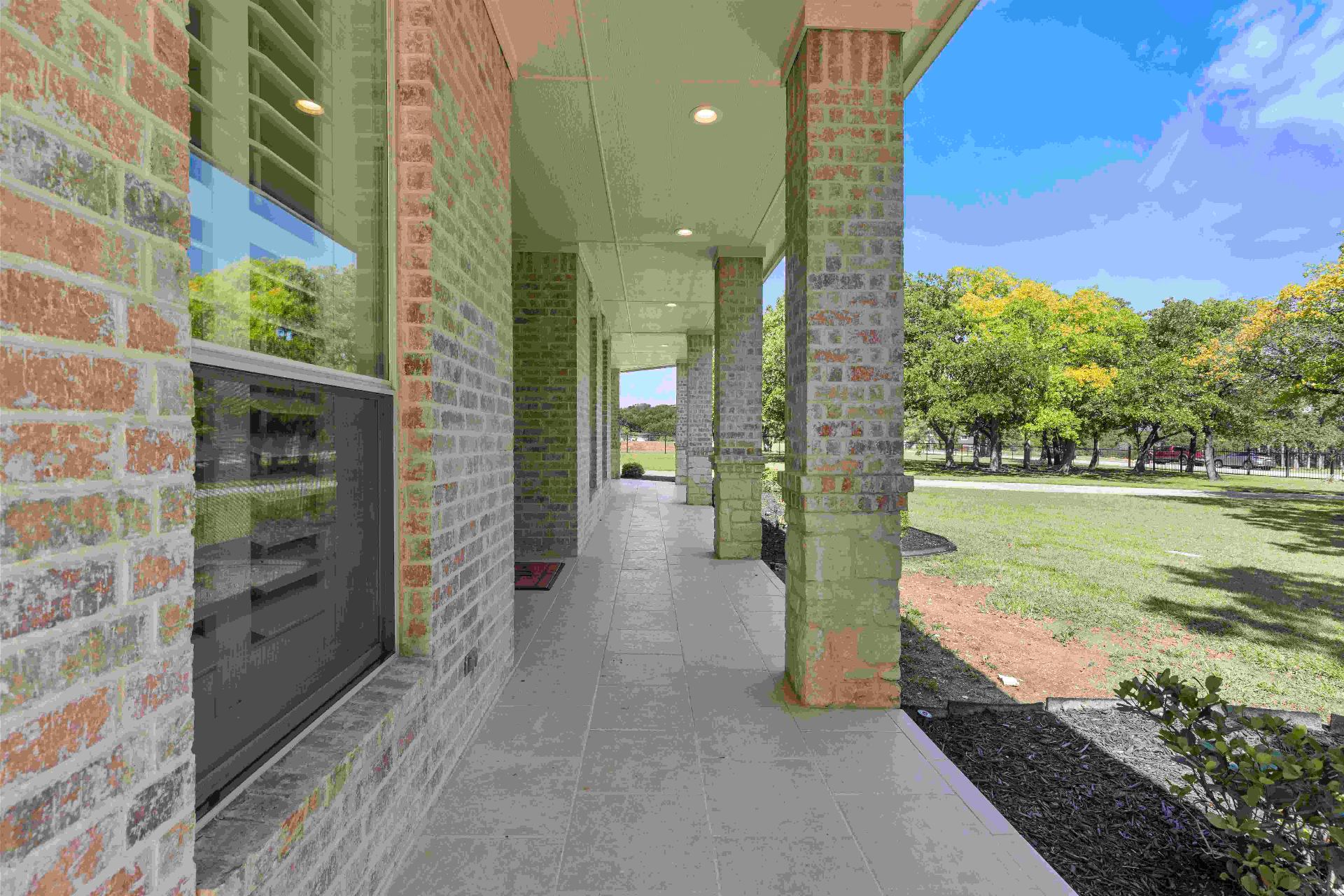 Covered front porch with brick columns and pasture views